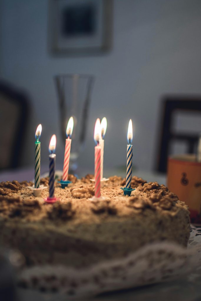 Close-up of a delicious birthday cake with colorful lit candles in a cozy setting.